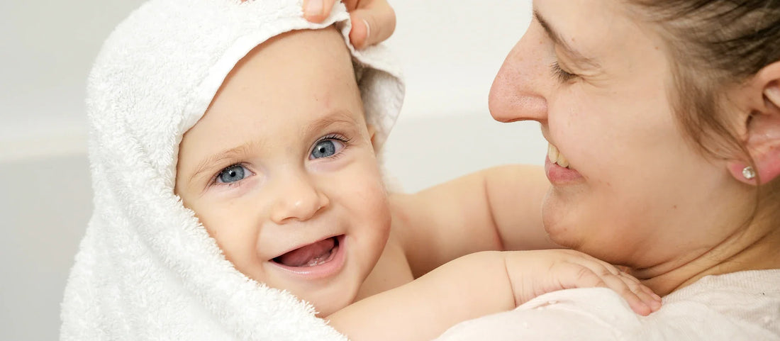 Säker dusch med babyguide som visar en skonsam teknik med handhållet duschmunstycke